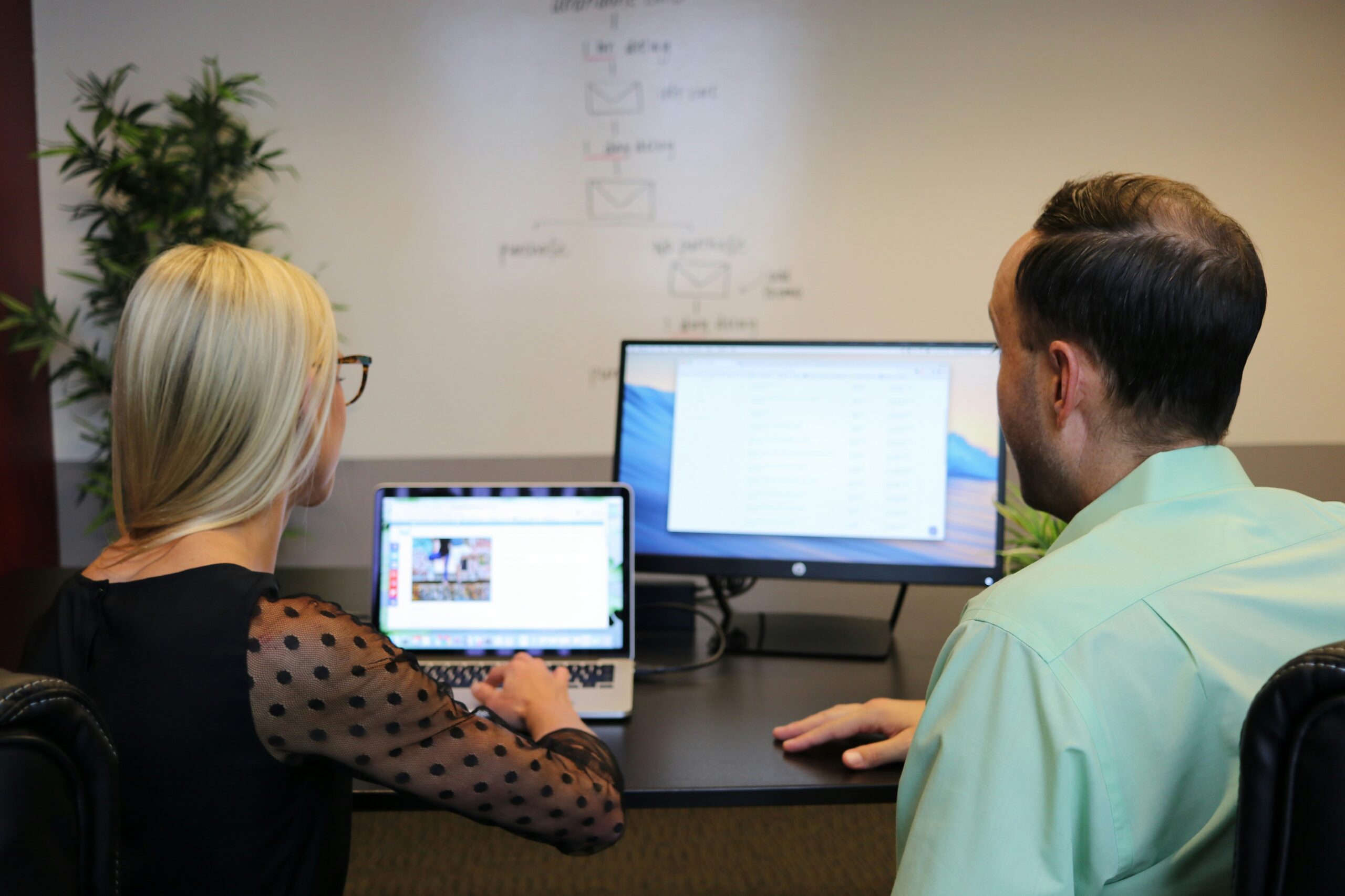 Two people looking at a monitro
