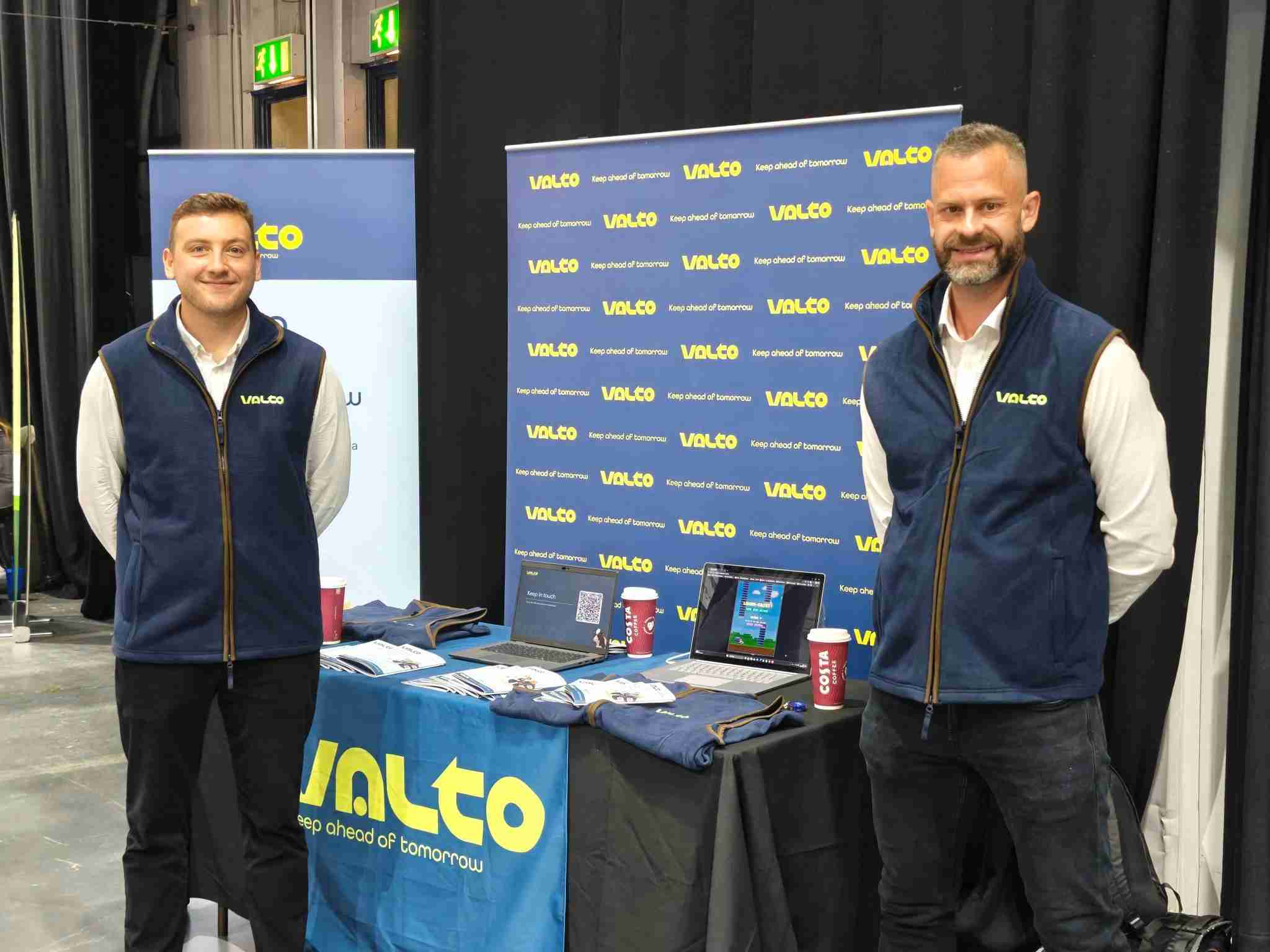 Two men standing at a stand