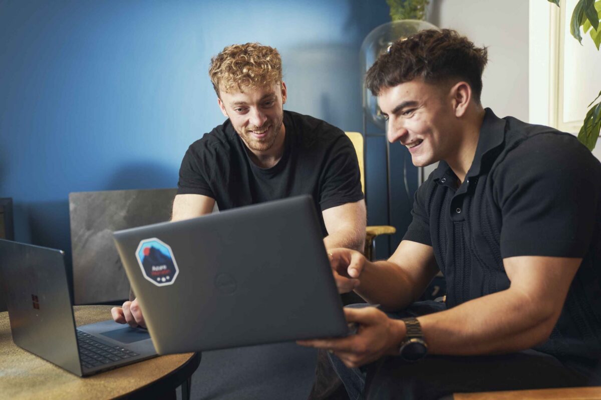 Two men sitting with laptops